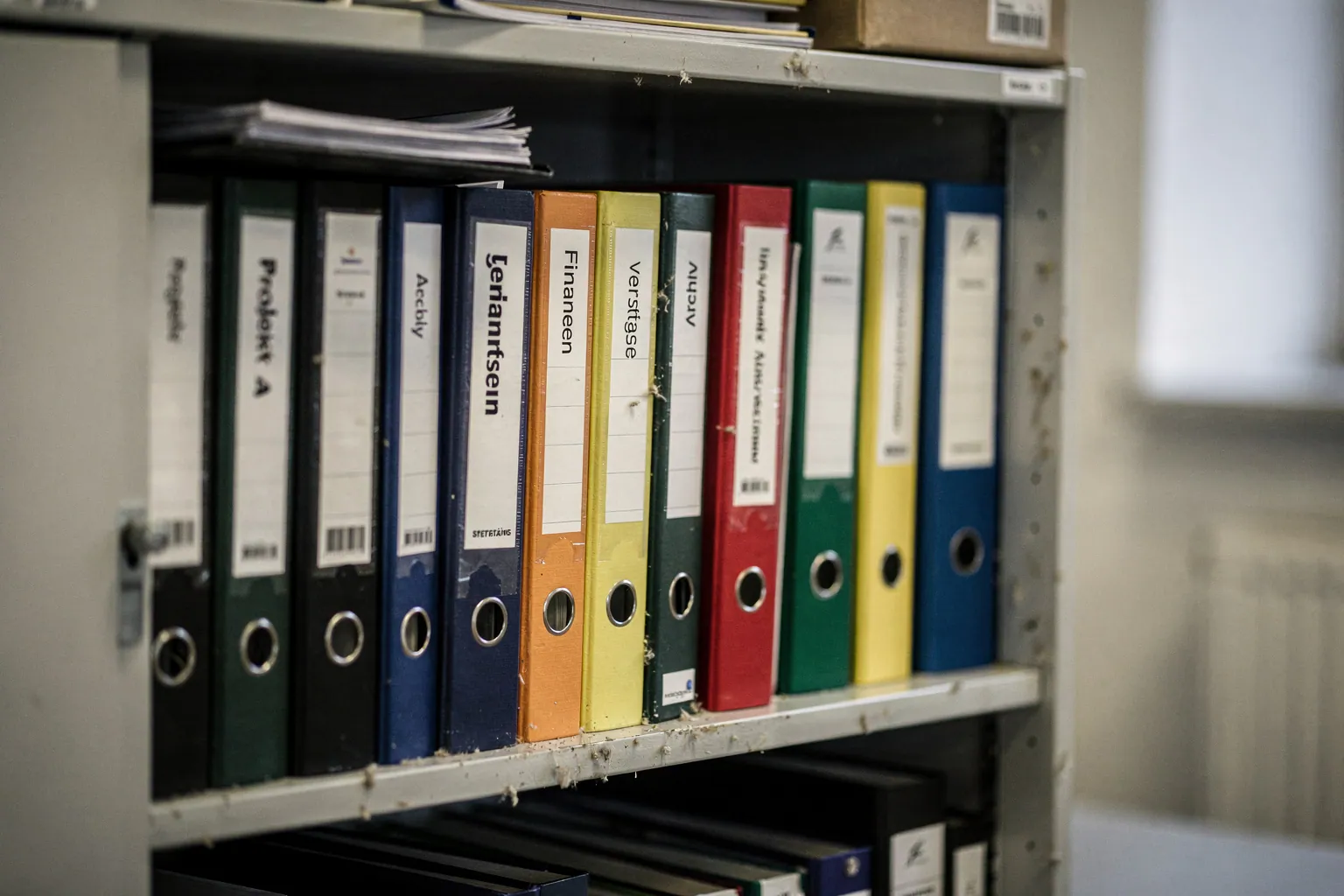 Offener Aktenschrank mit einer Reihe beschrifteter Ordner