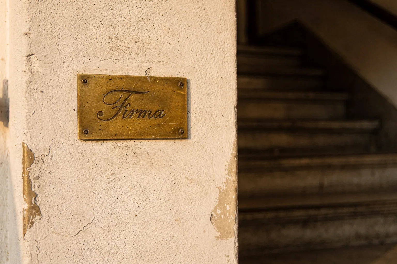 Messingschild mit dem Firmennamen an der Wand im Eingangsbereich